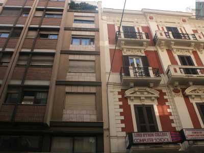 Foto 11. Proseguendo, vicino a uno scialbo palazzo in cemento color bronzo e mattonelle marroni privo di balconi, troviamo un altro splendido edificio d�epoca rosso scuro sede di una scuola d�inglese 